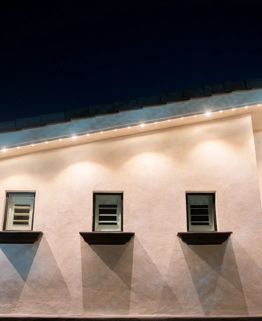 Close-up of the brite bird track lit warm white under a clean eave